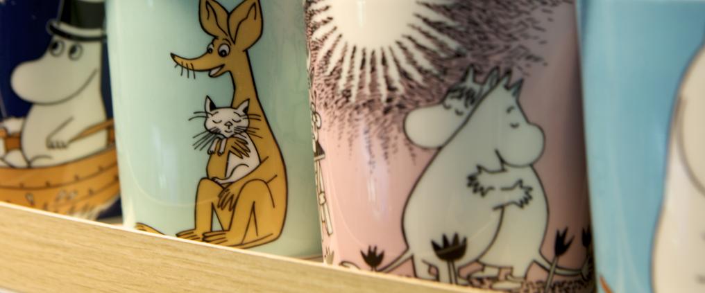 Moomin mugs on a shelf.