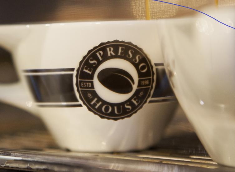 Lähikuvassa Espresso Housen logolla varustettu kahvimuki.