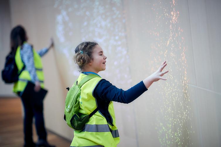 Girl is interacting with interactive light projection.