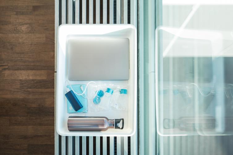 Liquid products and electronics on a security control tray.