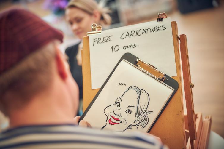 Artist drawing a caricature of a customer.