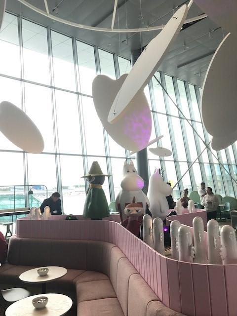 Moomin themed coffee shop interior. Seats and Moomin character statues.