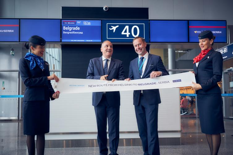 Air Serbia ribbon cutting event in front of a boarding gate.