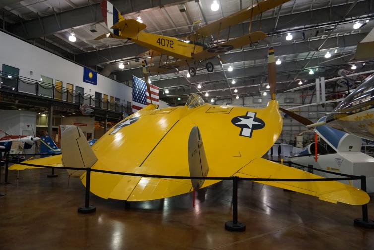 A yellow flat airplane (flying pancake) inside flight museum.