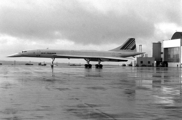 濡れたアスファルト上の飛行機の古い黒と白の写真。