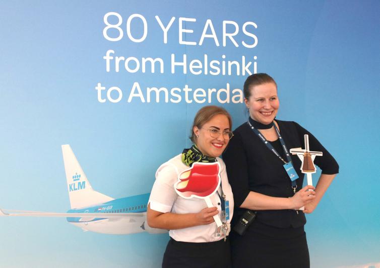 Kaksi KLM:n porttivirkailijaa poseeraa kuvaajille tapahtumassa.