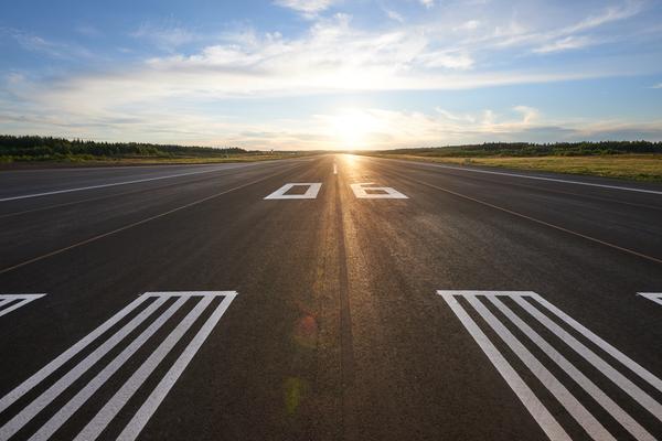 Aurinko paistaa kiitotien päässä. 