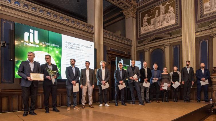 Joukko ihmisiä ottamassa vartaan palkintoa