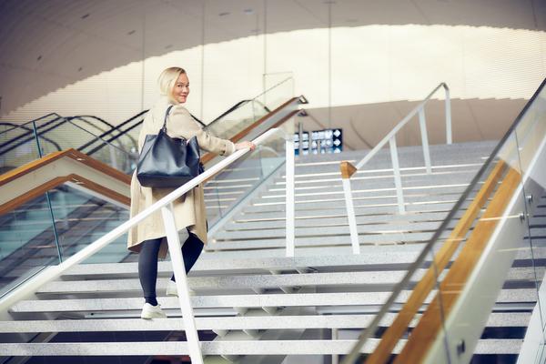  Nainen kävelee portaissa Helsinki-Vantaan lentoasemalla.