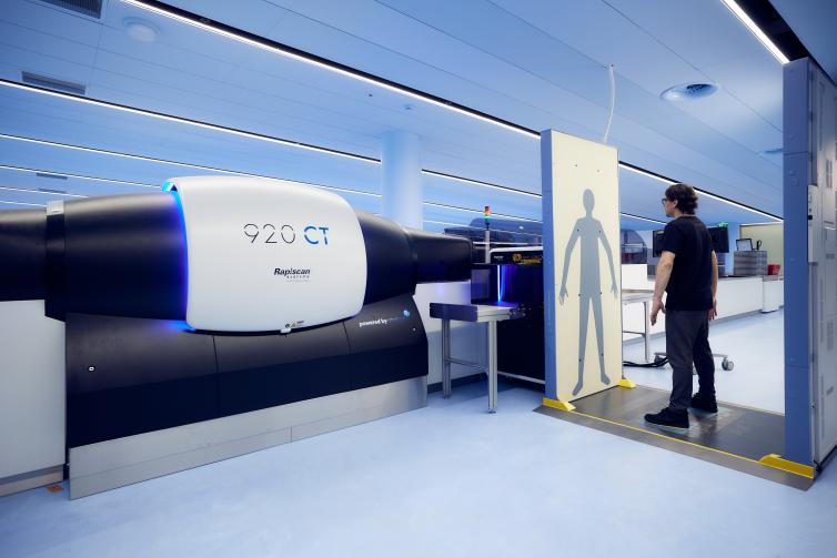 A passenger stands in front of a security scanner