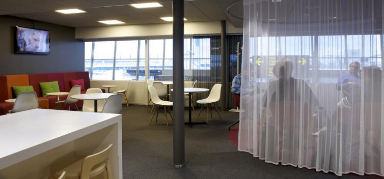 Lounge with round tables surrounded by chairs.