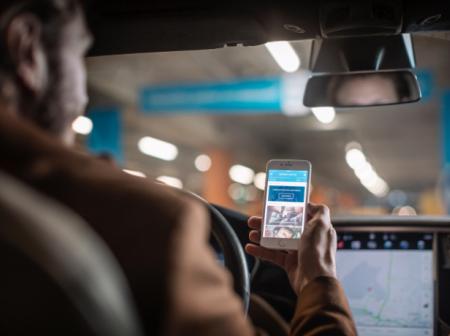 Man sitting in the car and watching his mobile phone