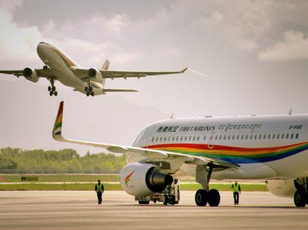 Kaksi Tibet Airlinesin lentokonettam, joista toinen on ilmassa ja toinen maassa.