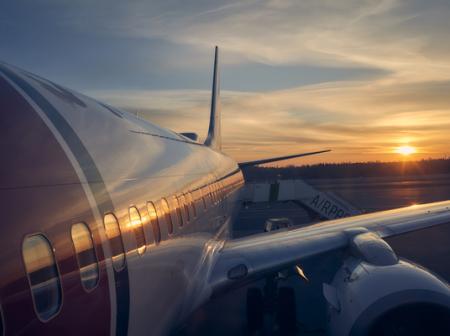 Norwegian-koneen kylki ja auringon lasku.