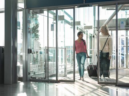 Passenger arriving through opening glass doors. 