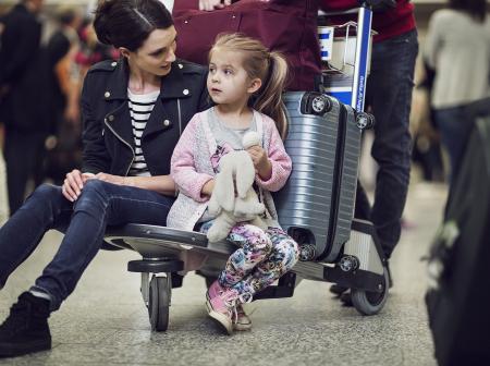 Lapsi istuu matkatavarakärryssä