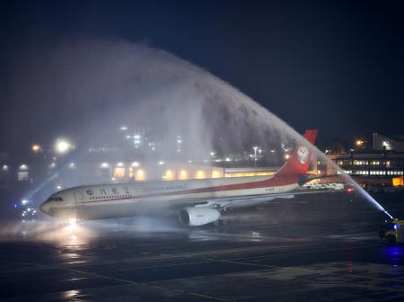 Sichuan Airlinesin lentokone saa vesitervehdyksen eli paloautot suihkuttavat vettä koneen päälle. 