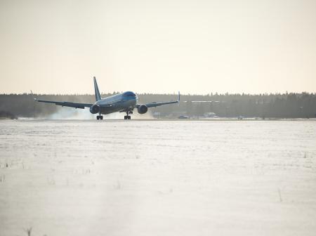 Lentokone laskeutuu talvisessa maisemassa