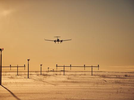 A plane landing in the sunset