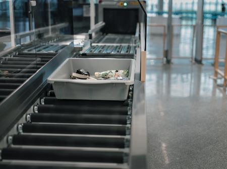 A close picture of the security control line and trays at Helsinki Airport