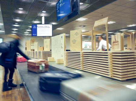 Henkilö ottaa matkalaukun pois matkatavarahihnalta