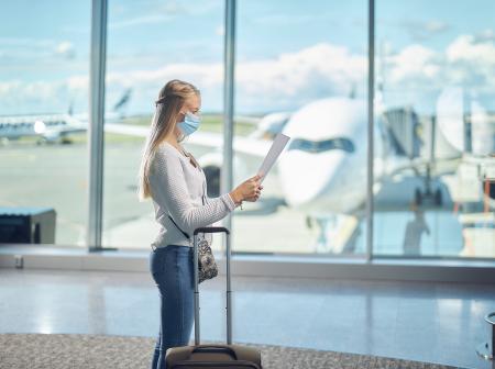 Nainen seisoo Helsinki-Vantaan lentoasemalla. 