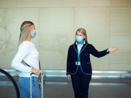 Terminaaliopas ohjaa matkustajaa.