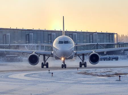 Lentokone ilta-auringossa, lumisella asematasolla