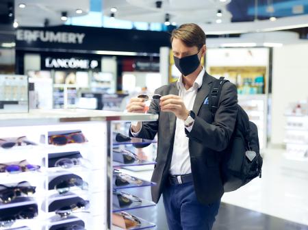 Passenger looking at sunglasses at Dufry store