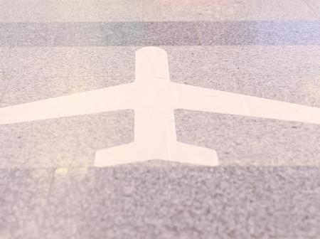 Lentokoneen muotoinen opastarra kivilattiassa.