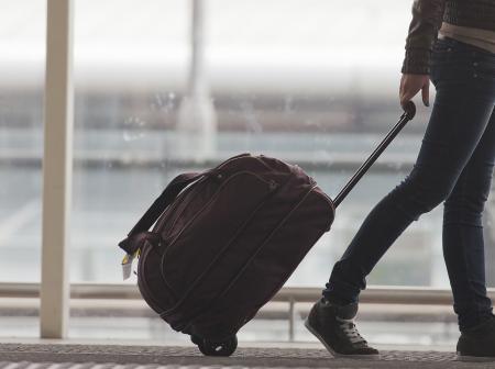 A passenger walking with luggage