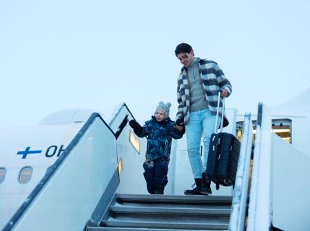 Lapsi ja aikuinen tulossa ulos lentokoneesta