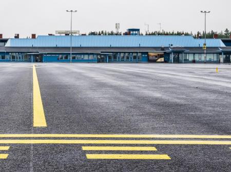 Kuvassa näkyy Kuusamon lentoaseman kiitotietä ja taustalla terminaalirakennus.