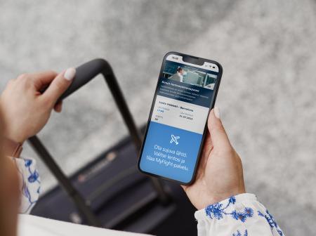 Matkustaja katsoo MyFlight -palvelua kännykästään.
