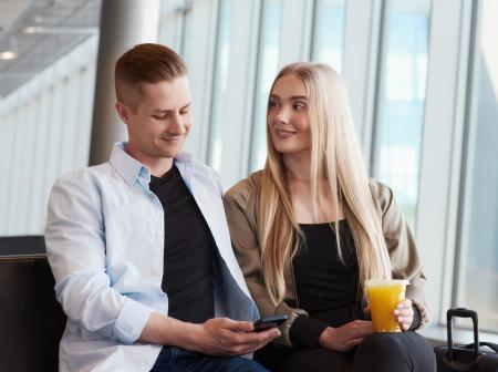 Matkustajat porttialueella istuskelemassa