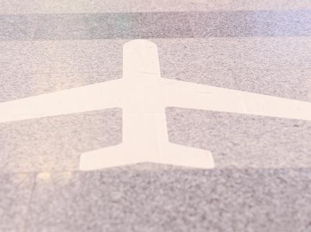 Lentokoneen muotoinen tarra kivilattiassa