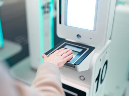 Käsi pitelee passia uudessa EES-järjestelmän lukijassa.