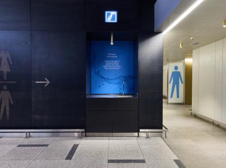 Passenger is taking water from water machine