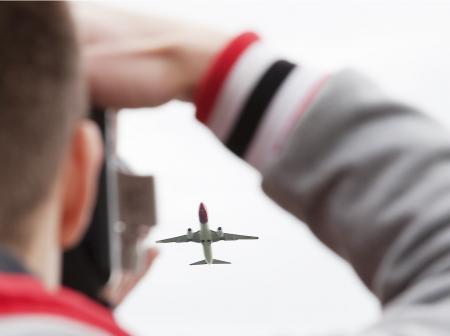 Mies ottaa valokuvan nousevasta lentokoneesta.