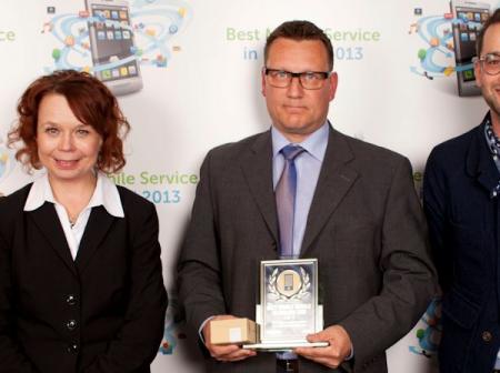 Three persons accepting a competition prize