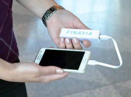 Person is holding a phone and portable charger.