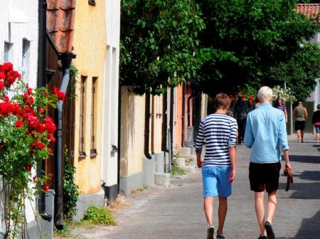 Two men walking on a street in a small town.