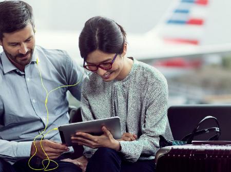 Man and woman watching something together from a tablet.