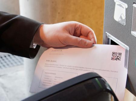 A man showing a receipt to a scanner.