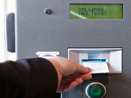 Customer is taking a parking ticket out of the parking machine.