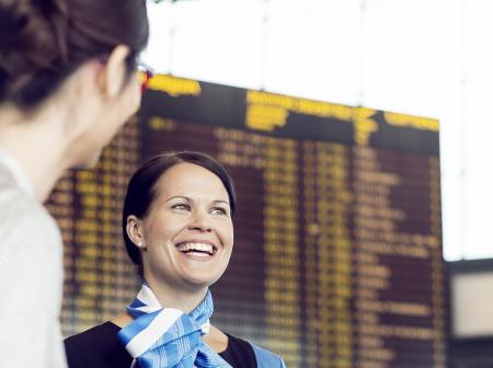 Smiley passenger adviser guiding her customers.