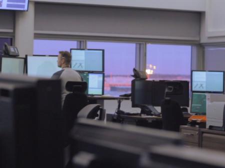 Air traffic controller working with multiple of monitors.