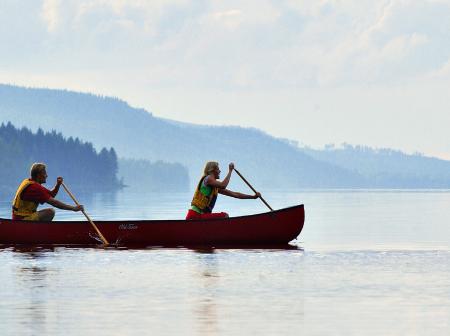 Two people canoeing in one canoe in the nature.
