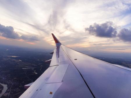 Cabin window view of aircraft wing.