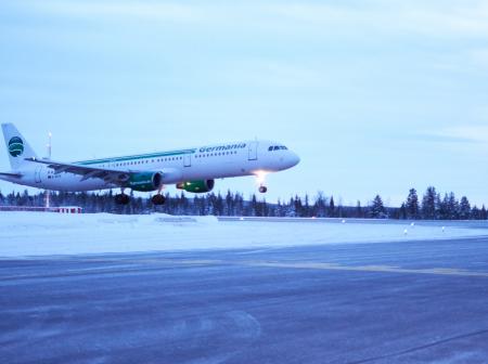 An airplane landing to a snowy runway.